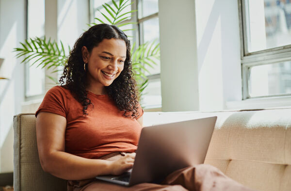 Mujer sonriendo durante sesión de terapia online desde casa